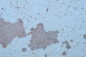 a wall with peeling blue paint